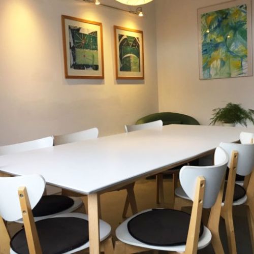 Billede af grupperum med stole borde og billede p&aring; v&aelig;ggen